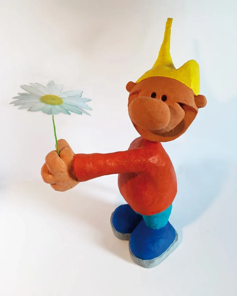Figurine B@d B°Y « Fleur » : il tend une marguerite en souriant